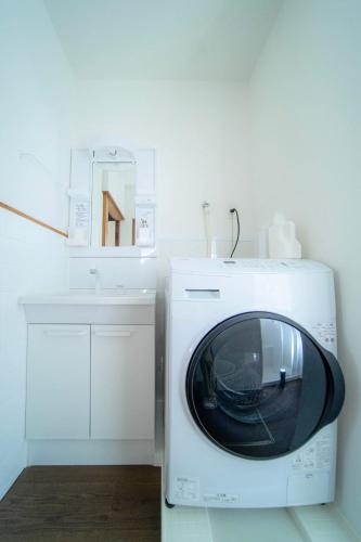 a microwave sitting next to a sink in a kitchen at 家族旅館四国周遊元山 in Takamatsu