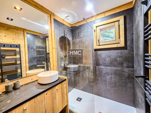 ein Badezimmer mit Waschbecken und Dusche in der Unterkunft Chalet K Jacuzzi et vue in Bolquere