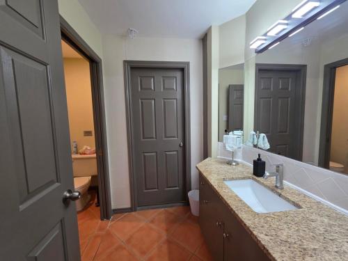 un bagno con un lavandino e un grande specchio di Oceanside GetAway at Pacific Shores a Nanoose Bay