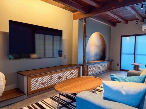 un soggiorno con un tavolo e una tv di SORAIRO Miyajima a Hatsukaichi
