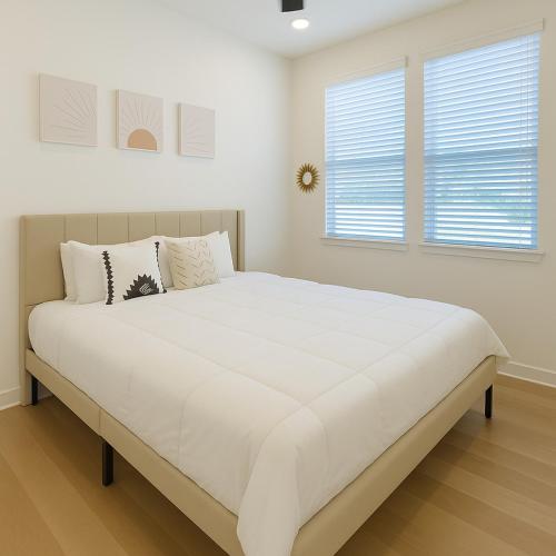 a large white bed in a room with two windows at Worker friendly A plus Location Warm and Cozy in Sherman