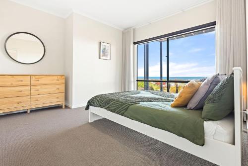 CarrickalingaにあるOcean Heights - 27 Stacey Driveのベッドと大きな窓のある寝室