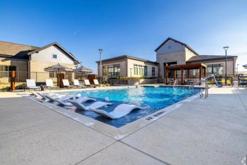 a swimming pool with lounge chairs and a swimming pool at WorkerFriendly KINGbed A plus Location Washer Wifi Pool in Sherman