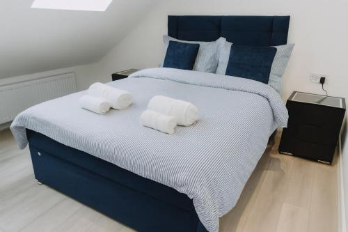een slaapkamer met een groot bed met handdoeken erop bij Urban Luxury in Colnbrook