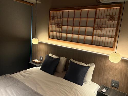 una camera da letto con un letto con uno specchio sopra di esso di SORAIRO Miyajima a Hatsukaichi