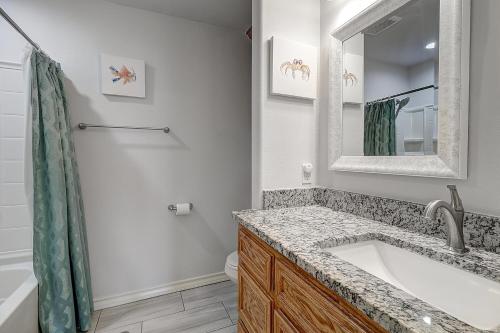 a bathroom with a sink and a mirror at A Wave From It All in Rockport