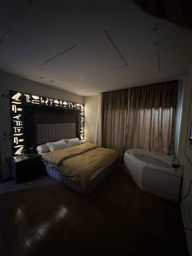 un dormitorio con una cama y una bañera en Golden pyramids temple view INN, en El Cairo