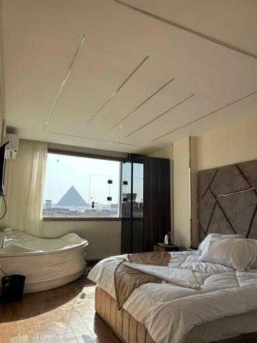 Un dormitorio con una cama grande y una bañera. en Golden pyramids temple view INN, en El Cairo