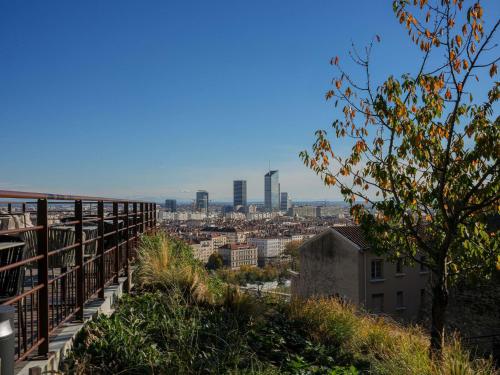 a view of the city from a balcony of a building at Hôtel Fort St Laurent Lyon - Handwritten Collection in Lyon