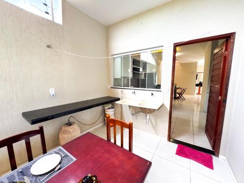 a kitchen with a table and a sink in a room at Casa victória Régia in Camocim