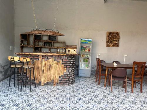 a dining room with a table and a refrigerator at Wood Haven Homestay in Ninh Binh