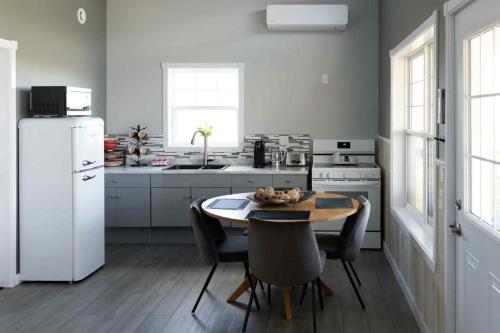 eine Küche mit einem Tisch und einem weißen Kühlschrank in der Unterkunft Down East Cabins in Tracadie