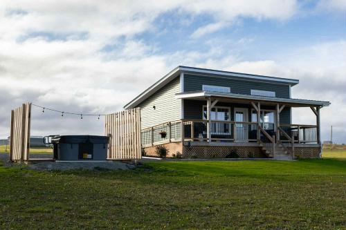 ein kleines Haus auf einem Feld mit einem Zaun in der Unterkunft Down East Cabins in Tracadie