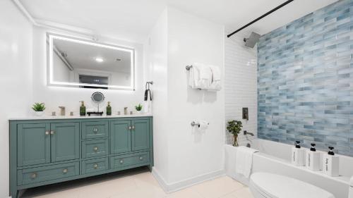 une salle de bains avec un meuble vert, une baignoire et un lavabo dans l'établissement Lodge-Style Home Near Gatlinburg w Theater Hot Tub Game Room Evergreen Escape by AvantStay, à Pittman Center