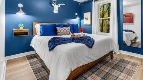 - une chambre bleue avec un grand lit aux murs bleus dans l'établissement Lodge-Style Home Near Gatlinburg w Theater Hot Tub Game Room Evergreen Escape by AvantStay, à Pittman Center