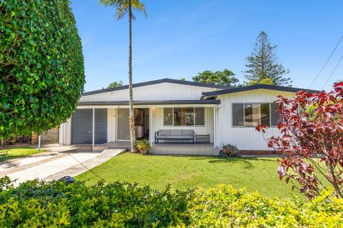 a white house with a palm tree in a yard at Nonna and Pops in Mylestom