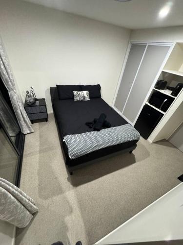 a bedroom with a black bed in a room at Cedarstone Villa in Halswell