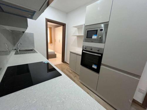 una cocina con estufa y microondas en Qawra Seaside Birch Leaf, en St Paul's Bay