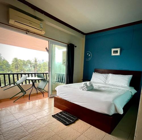 a bedroom with a large bed and a balcony at Beach House 24 in Ko Lanta