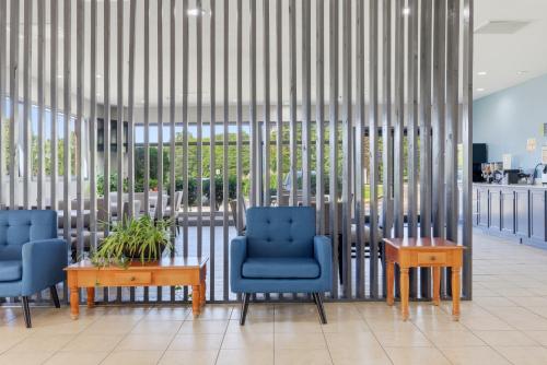 een lobby met twee blauwe stoelen en een tafel bij Days Inn & Suites by Wyndham Wynne in Wynne