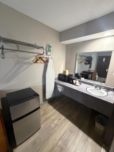 a bathroom with a sink and a mirror at Colonial Inn in Shawnee