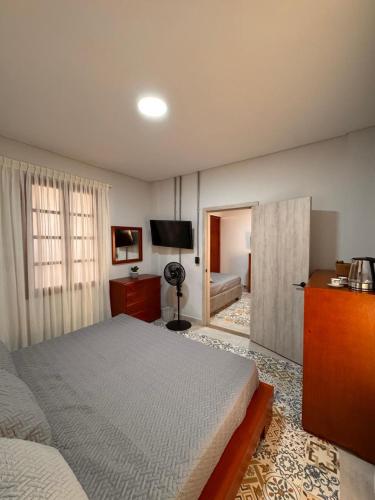 una camera da letto con un letto e una televisione di Hotel Campestre Alma Nativa a Calarcá