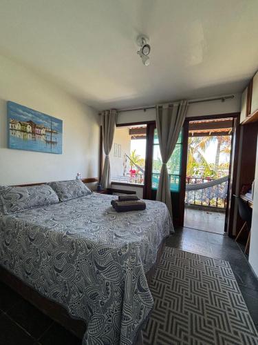 a bedroom with a bed with a blue comforter at Le Corsaire in Búzios