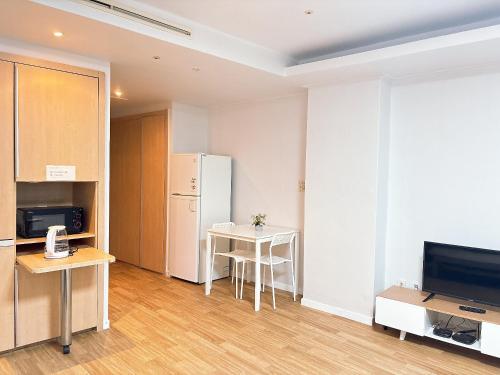 Una cocina con un refrigerador blanco y una mesa. en 温馨小屋Cozy House, en Incheon