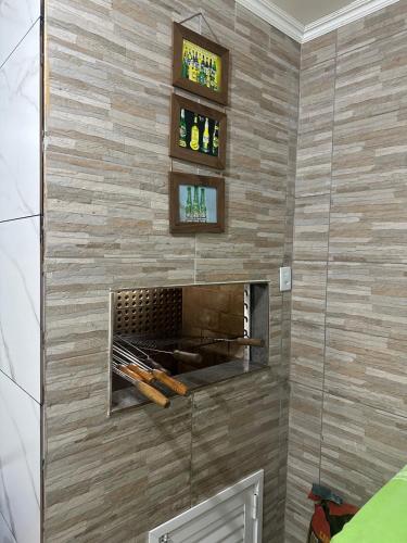 a brick wall with a fireplace in a room at Casa com Piscina in Arroio do Sal
