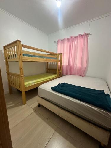 a bedroom with a bunk bed and a window at Casa com Piscina in Arroio do Sal