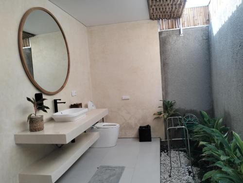 a bathroom with a sink and a mirror at Villa Puri Mesari Amed in Amed