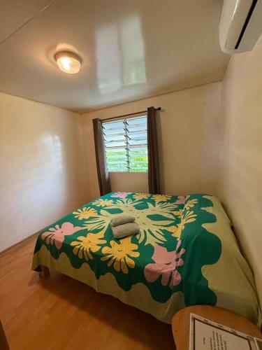 a bedroom with a bed with a flower pattern on it at Chez Aroro Beach House in Avatoru