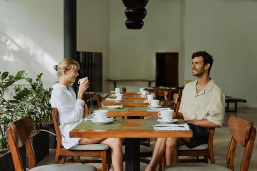 a man and a woman sitting at a table at Hotel Nya in Montezuma