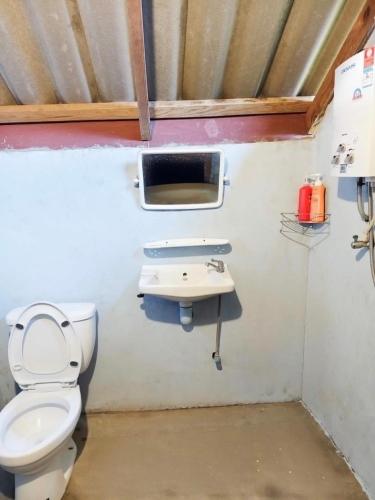 a bathroom with a toilet and a sink at Angha forest view บ้านกลางนา in Ban Sop Mae Klang