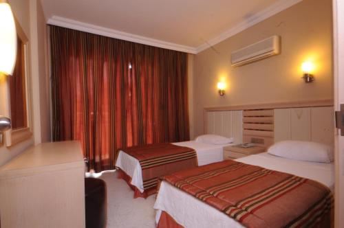 a hotel room with two beds and a window at Candan Apart in Marmaris
