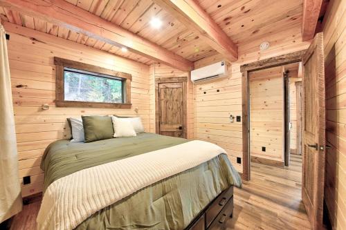 una camera da letto con un letto in una cabina di legno di Hidden Valley Haven a Sandpoint