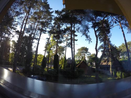 a view of a window with trees and a house at Kambarių nuoma Kačerginės kurorte in Kačerginė