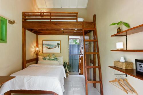 a bedroom with a bunk bed and a ladder at Amy's Place Sumatra in Krui