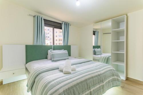 a bedroom with a large bed with towels on it at Serenada 2BR Apartment In Batroun in Batroûn