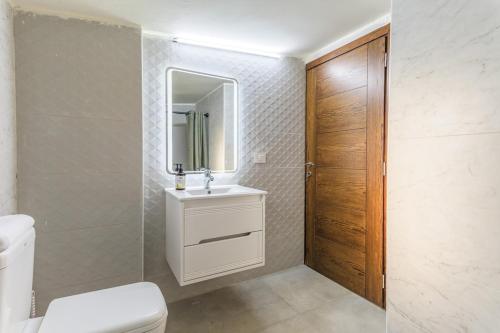 a bathroom with a toilet and a sink and a mirror at Serenada 2BR Apartment In Batroun in Batroûn