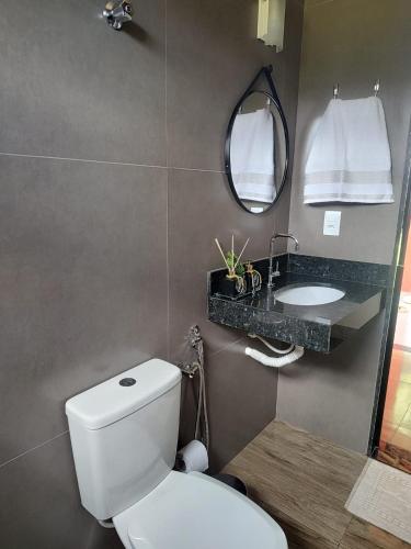 a bathroom with a white toilet and a sink at Tríade Chalé da Canastra 1 in São Roque de Minas