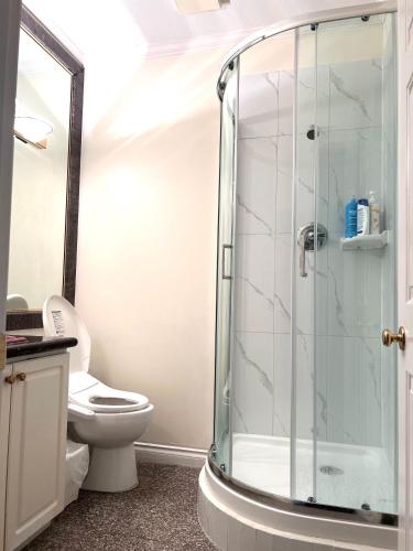 a bathroom with a toilet and a glass shower at Private 2BR, 1BA with shared Kitchen in a House, Free Parking, 15 Min YVR in Richmond