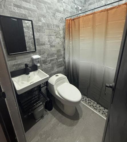 a bathroom with a white toilet and a sink at Suite La Lomita #2 climatizada in Tuxtla Gutiérrez