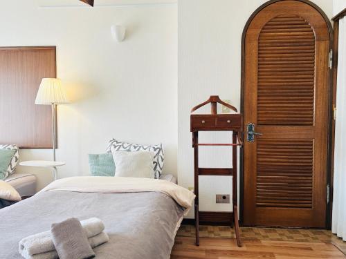 a bedroom with a bed and a wooden door at JOY HOUSE Near Ikebukuro in Tokyo