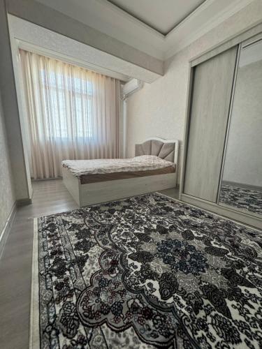 a bedroom with a bed and a rug at Уютный Апартамент Новостройка 舒适公寓 in Tashkent