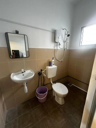 a bathroom with a sink and a toilet and a mirror at Fawa Homestay Jasin in Jasin