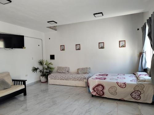 ein Wohnzimmer mit zwei Betten und einer Couch in der Unterkunft Quinta la hermosa in Villa María