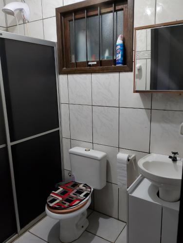 a bathroom with a toilet and a sink at POUSADA TEMPORADA BIBi casa inteira com café in São Gabriel
