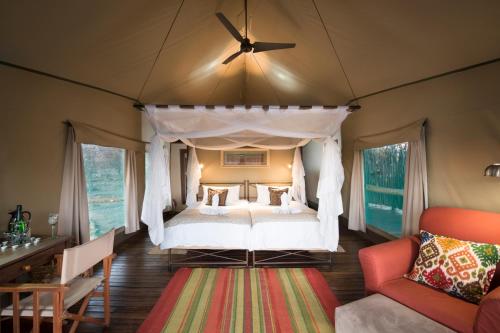 een slaapkamer met een hemelbed in een tent bij Ongava Tented Camp in Okaukuejo
