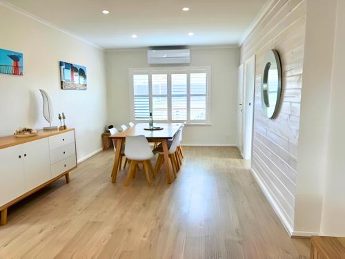 a kitchen and dining room with a table and chairs at Stones Throw to Beach & Chiton Surf Club in Hayborough